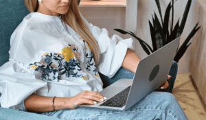 female health coach blogging from home on her laptop