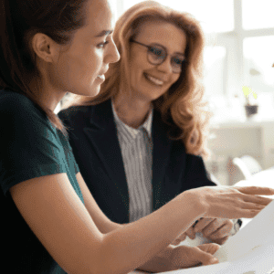 SEO strategy session between two women sitting at a desk, looking at a computer together