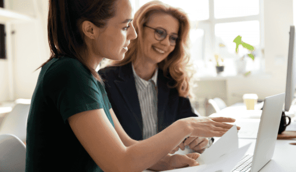 SEO strategy session between two women sitting at a desk, looking at a computer together