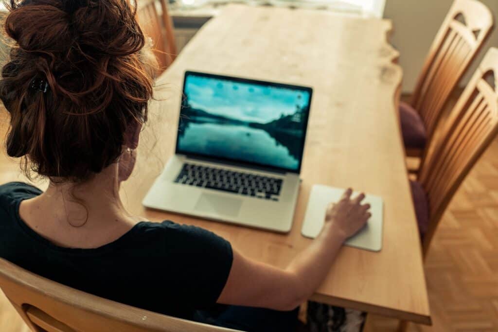 girl sits at her computer with her back to the camera wondering how to get more traffic to her website 