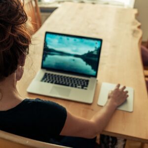 girl sits at her computer with her back to the camera wondering how to get more traffic to her website