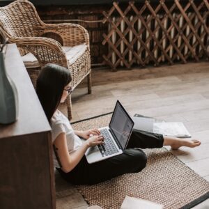 Woman sits on the floor improving her SEO for her online business
